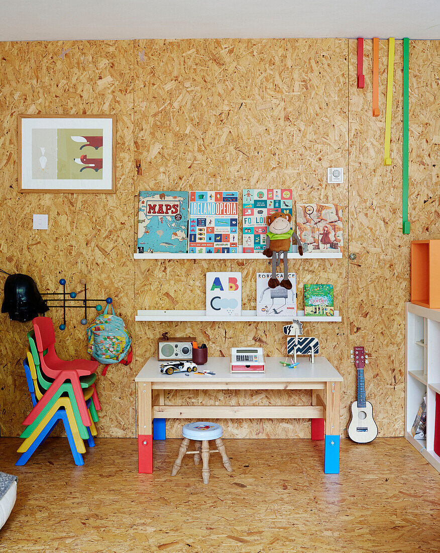 Storybooks and table with stacked chairs and cork walls in child's room Sligo newbuild, Ireland