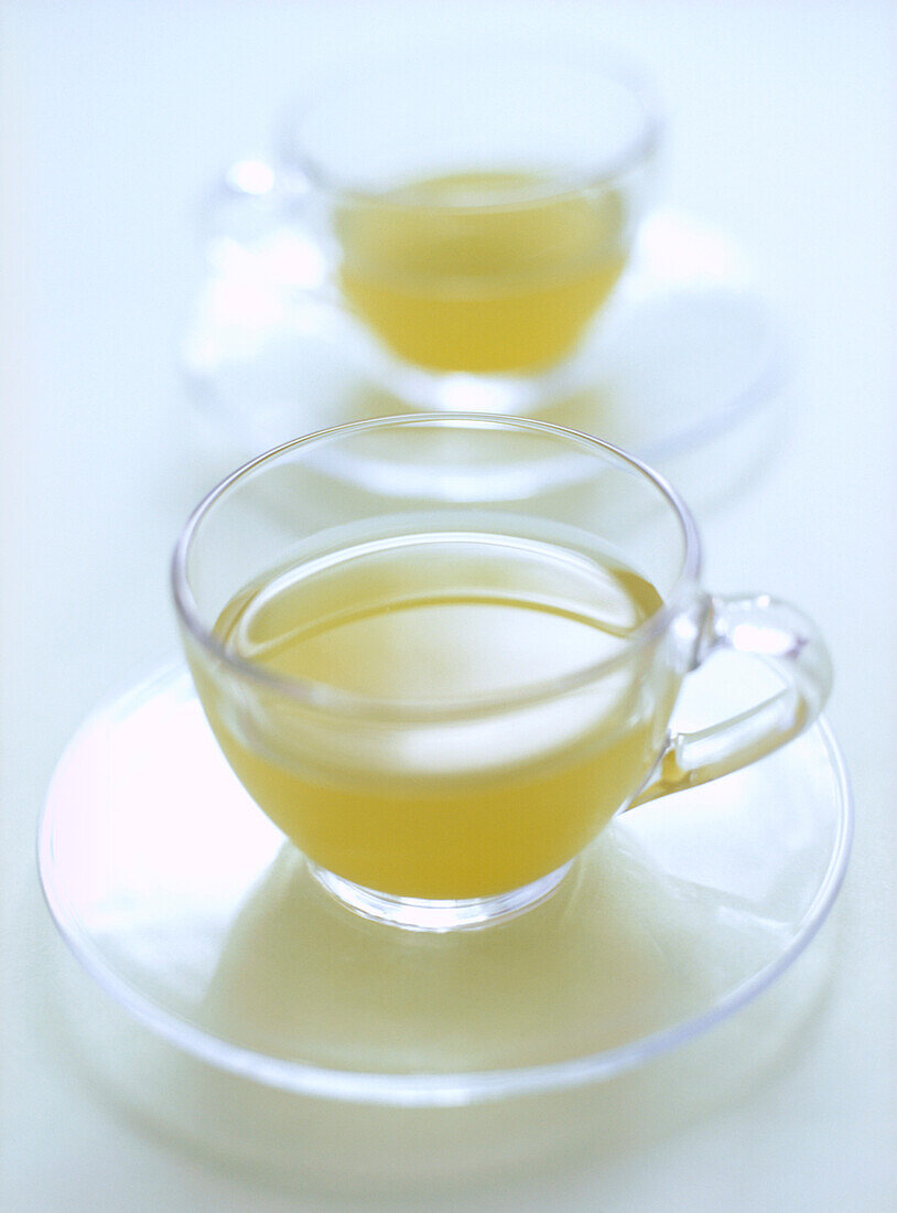 Grüner Tee in Glastassen und Untertassen