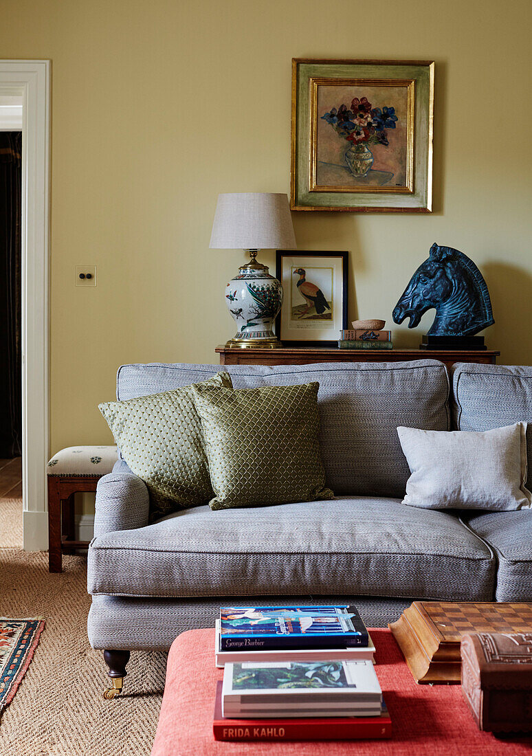 Equestrian bust and grey sofa with ottoman and books in North Yorkshire farmhouse, UK