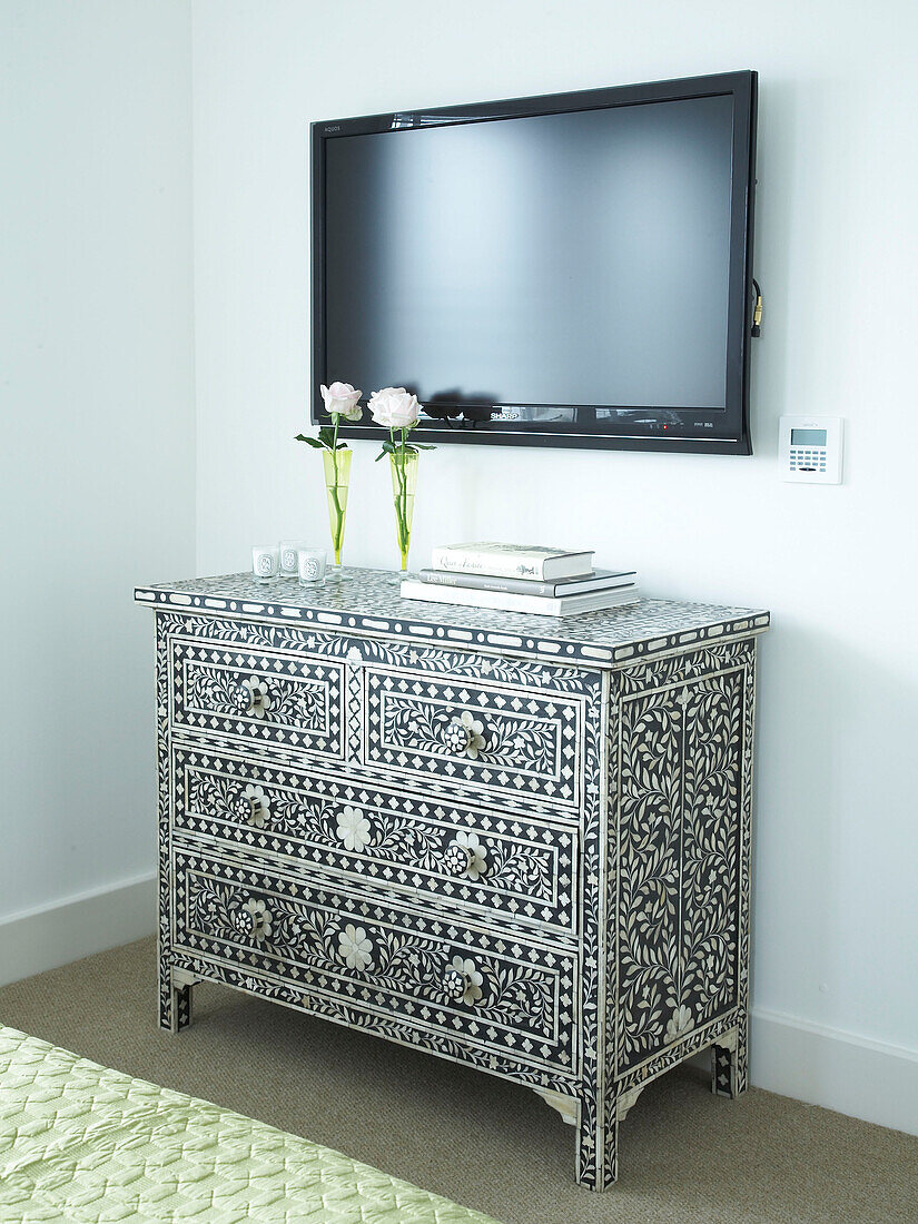 Decorative chest of draws in a bedroom with TV