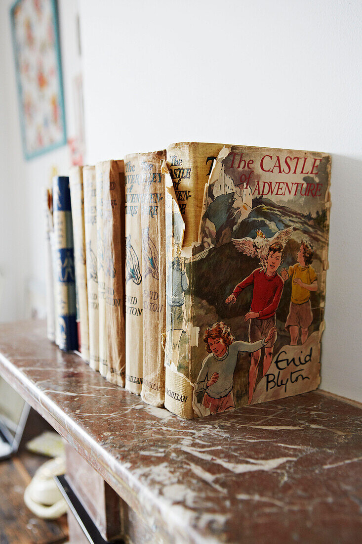 Alte Kinderbücher auf dem Kaminsims in einem Familienhaus in Colchester, Essex, England, UK
