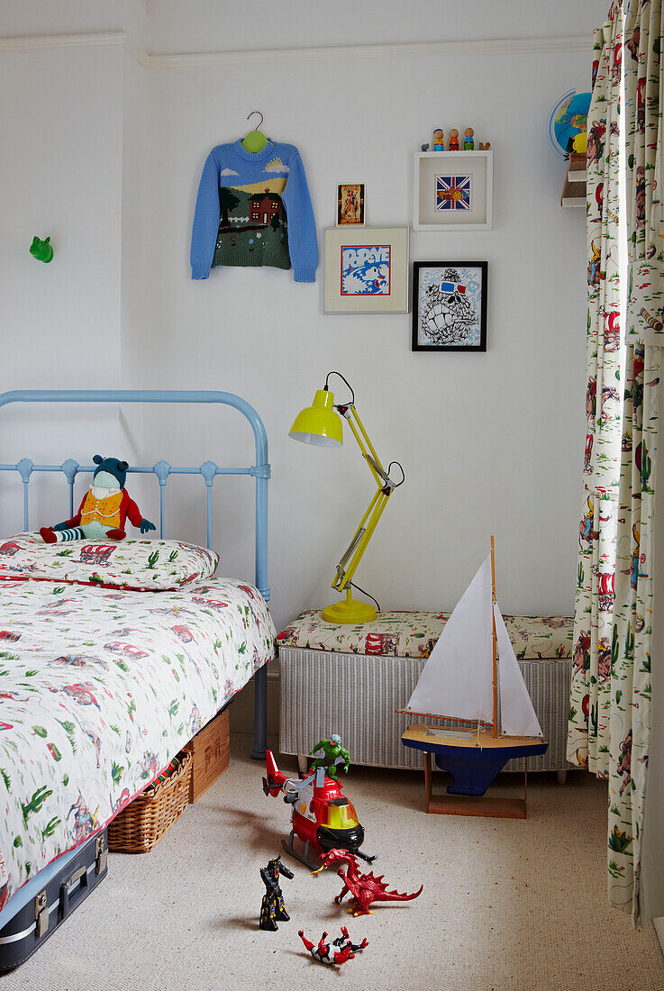 Schreibtischlampe am Bett in einem Jungenzimmer mit Spielzeug in einem Familienhaus in Colchester, Essex, England, UK