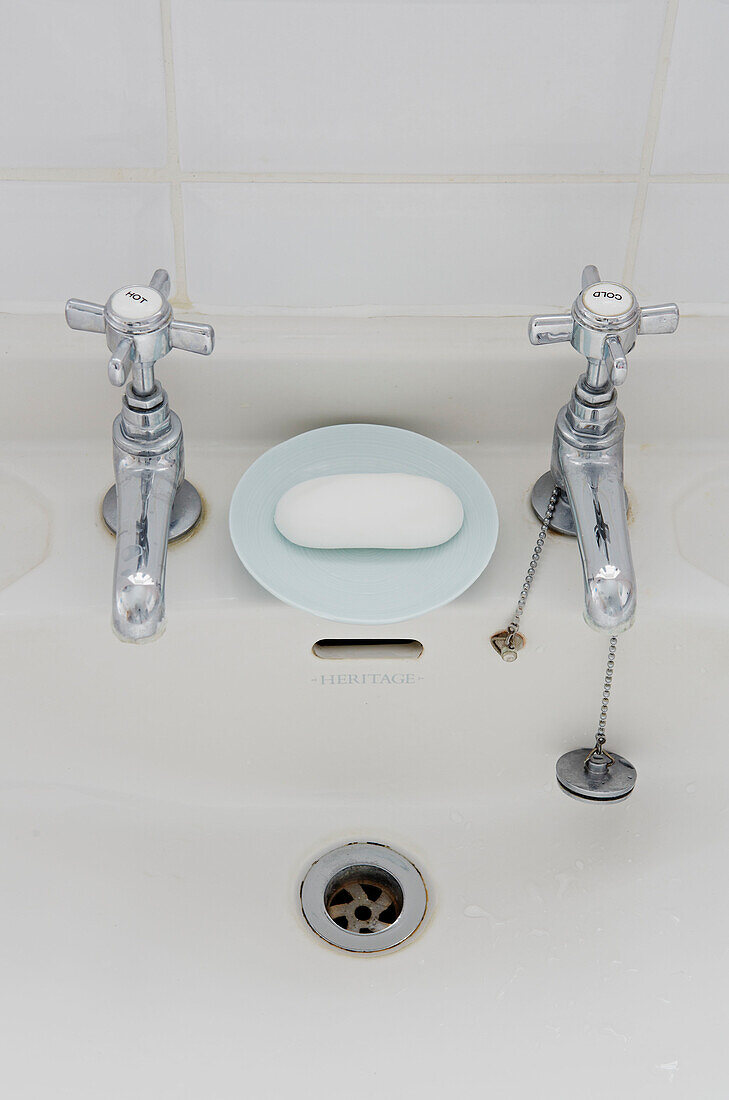 Verchromte Armaturen und Seifenschale am Waschbecken in einem Einfamilienhaus in Colchester, Essex, England, UK