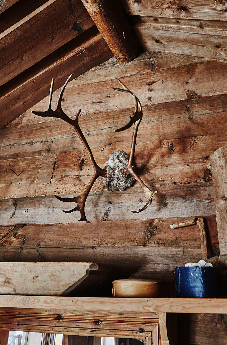 Ein Hirschgeweih hängt über der Tür des Wohnzimmers einer Holzhütte in den Bergen von Sirdal, Norwegen