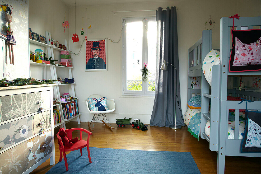 Wallpapered chest of drawers and light blue painted bunkbed in child's room of family home, France