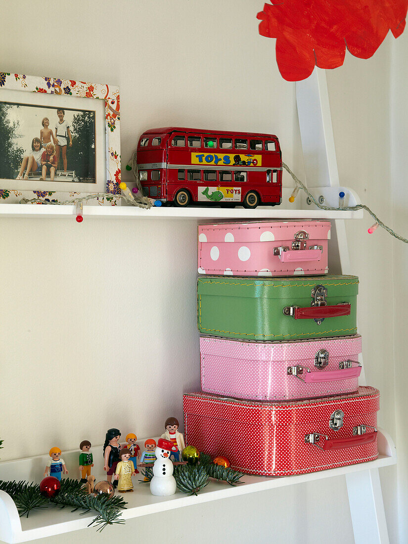 Verschiedene Koffer und Spielzeuge auf Regalen im Kinderzimmer eines Familienhauses in Frankreich