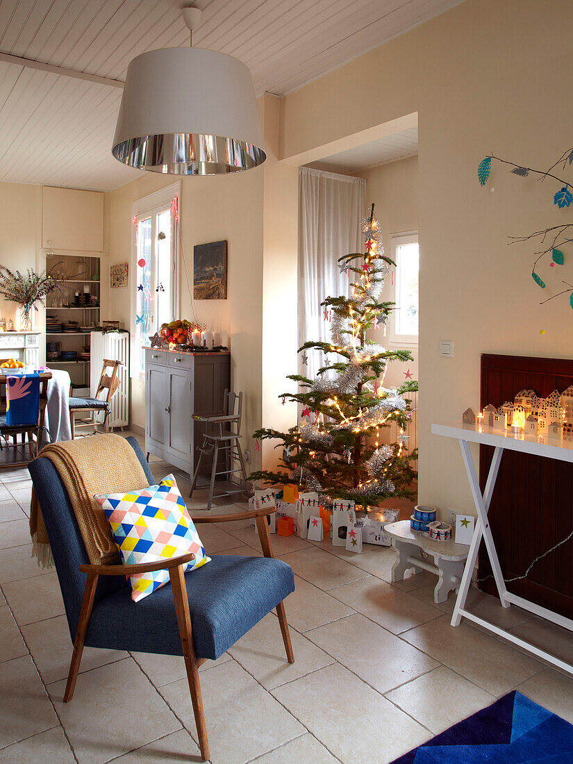 Blauer Vintage-Sessel und Weihnachtsbaum im Wohnzimmer eines Familienhauses in Frankreich