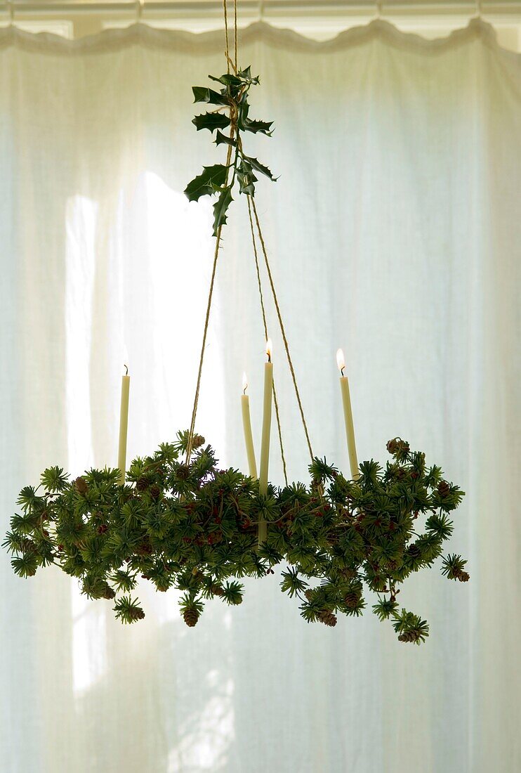 Hanging Christmas wreath with burning candles