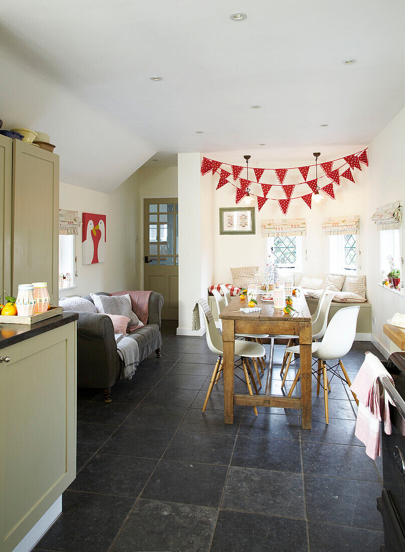 Festive bunting hangs above table in the kitchen in Herefordshire cottage, England, UK