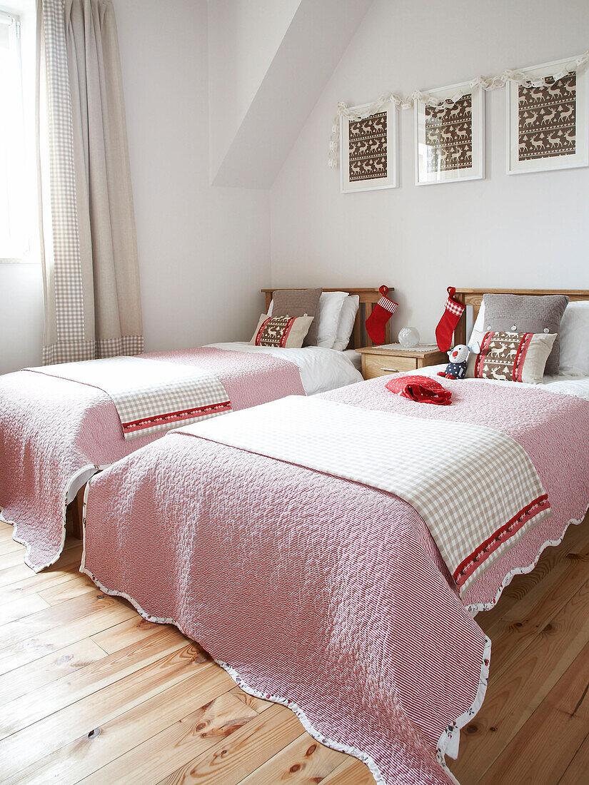 Twin beds with Christmas stockings in Polish home