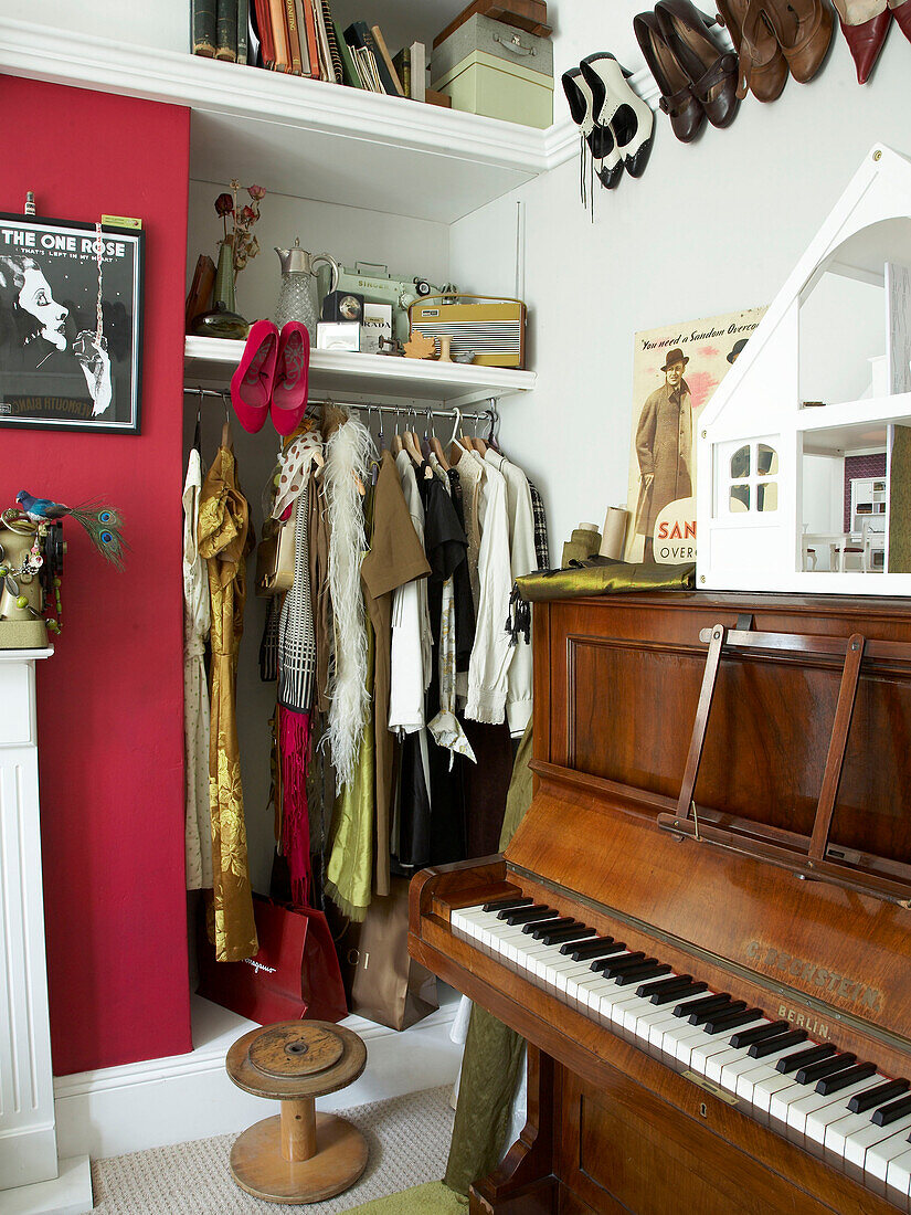 Vintage clothing and piano in bedroom of Winchester home, Hampshire, UK