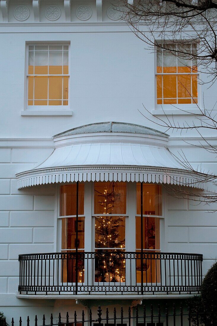 Beleuchteter Weihnachtsbaum im Hausfenster