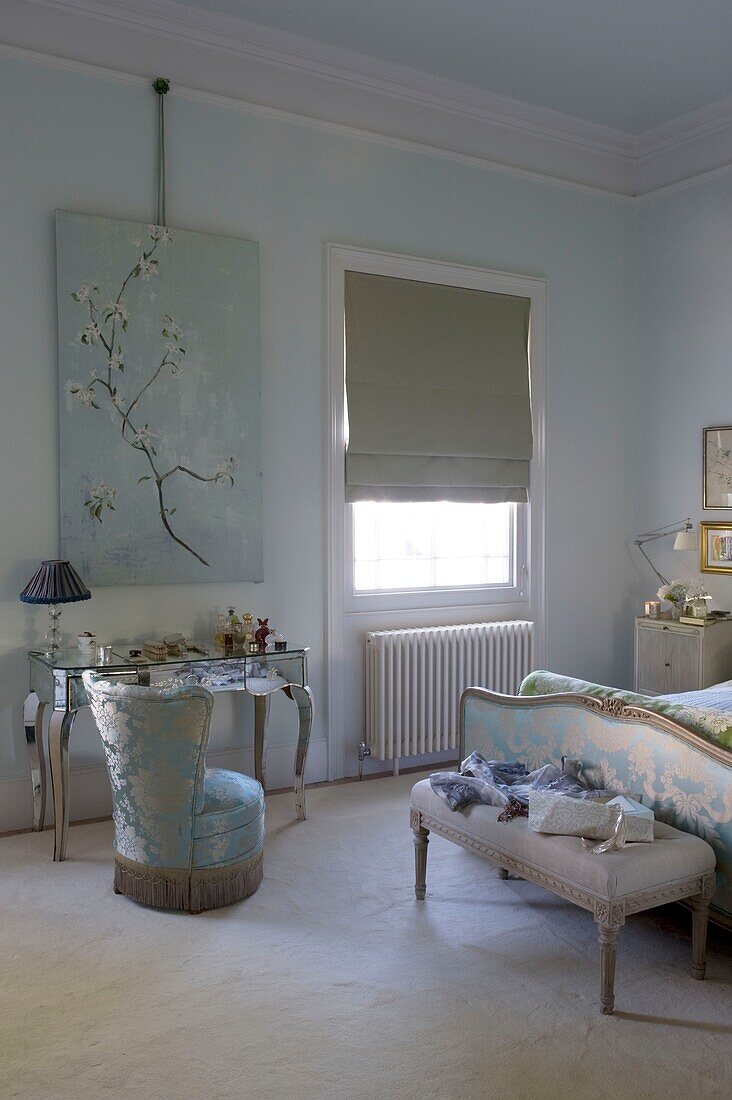 Bedroom with mirrored dressing table and silk upholstered chair with coordinated headboard