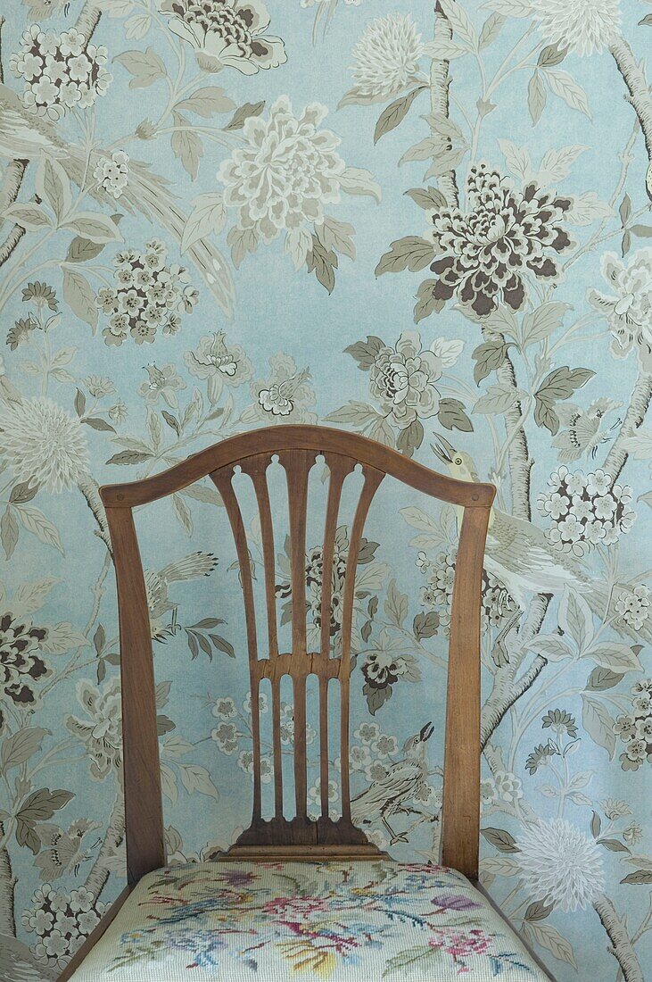 Stuhl, Tapete mit floralem Muster dahinter