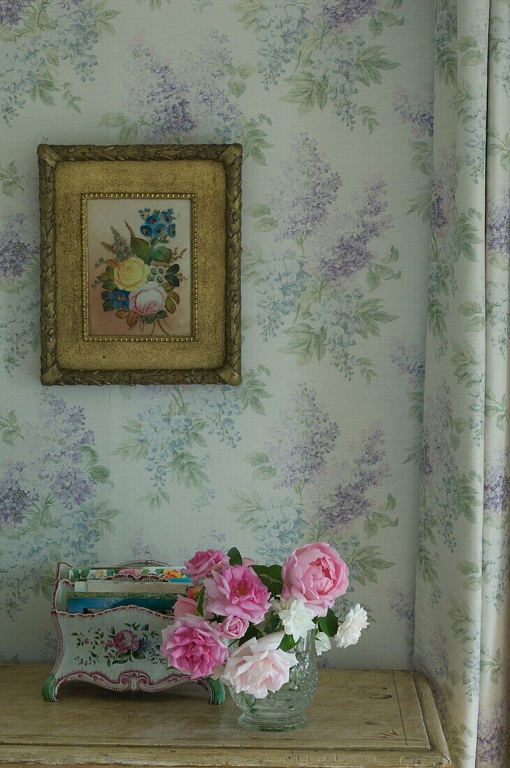 Still life with rose in vase, wallpaper with floral pattern behind