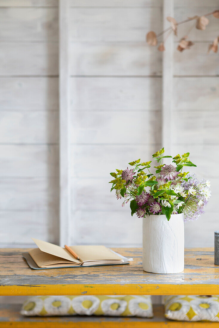 Notizbuch und Blumen auf Tischplatte im Atelierschuppen Guildford Surrey UK