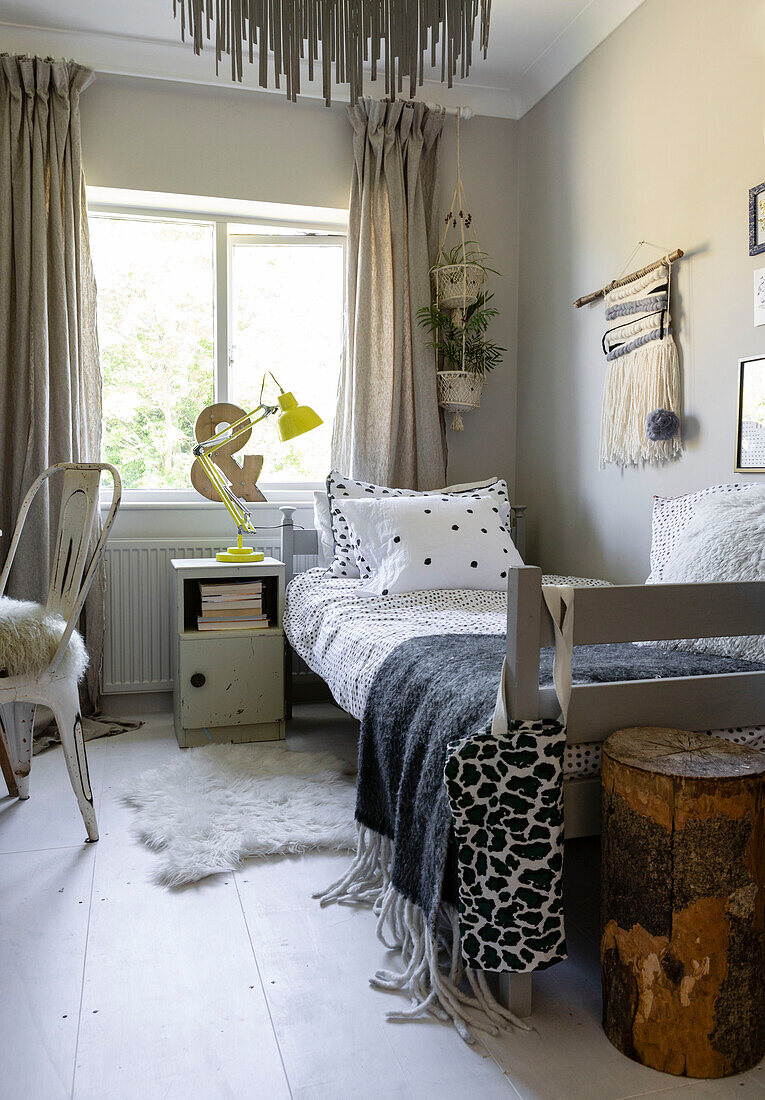 Leinenschafsfell aus Wolle und Baumwolle mit Einzelbett am Fenster in einem Haus in Colchester, Essex, UK