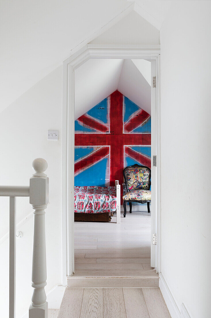 Blick durch den Flur auf den leuchtenden Union Jack im Zimmer des Jungen in einem Haus in Guildford, Surrey, Großbritannien