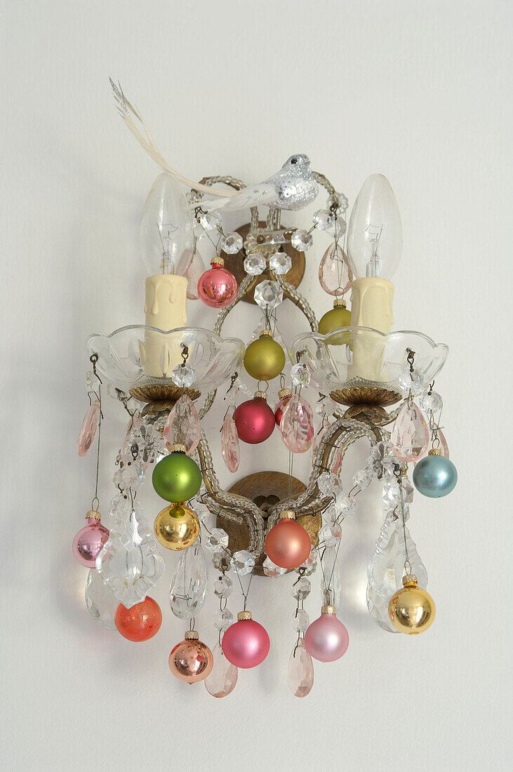 Christmas bauble decorations hanging on a wall light