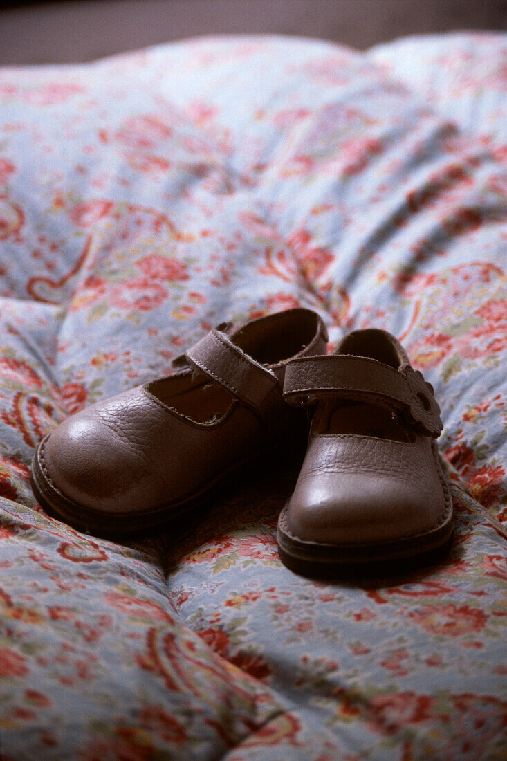 Detail of a pair of child's shoes on a bed