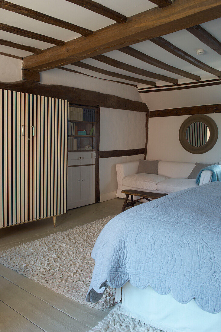 Striped wardrobe and beamed ceiling in Hastings cottage bedroom