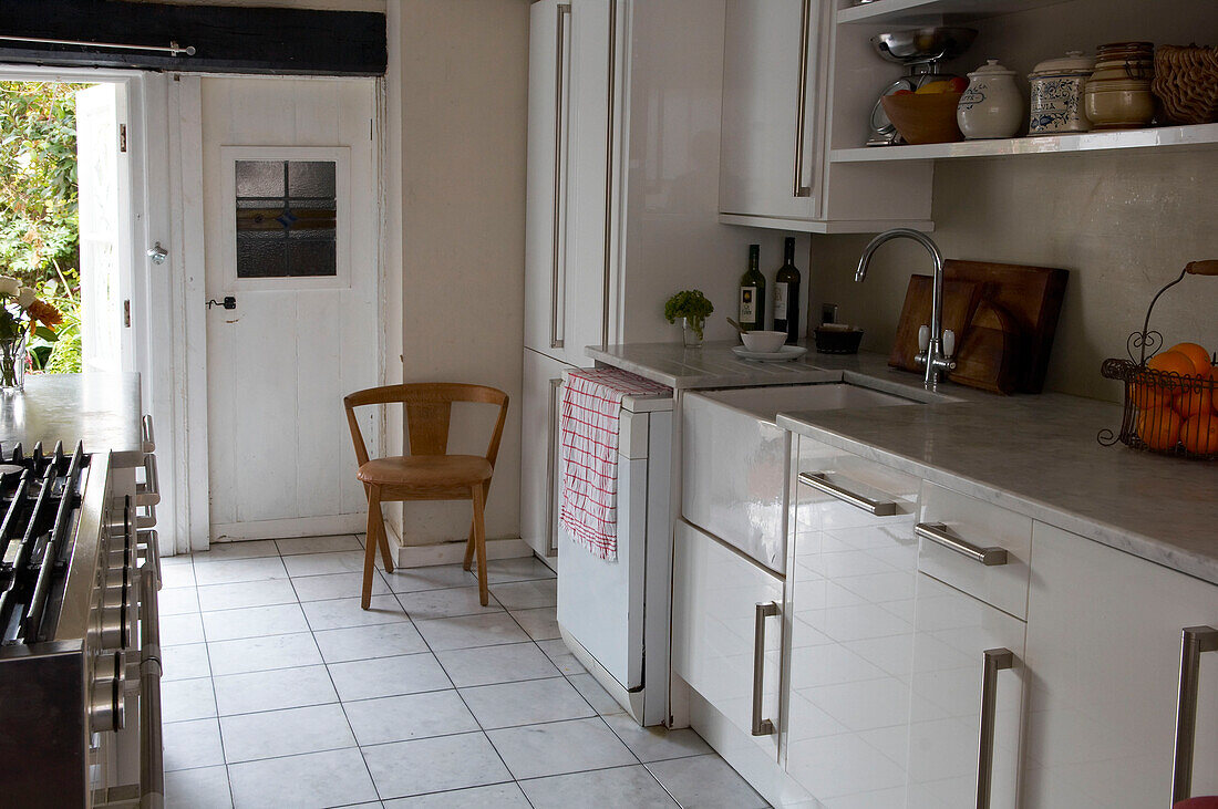 Weiße Küche mit gefliestem Boden und offener Hintertür in Hastings