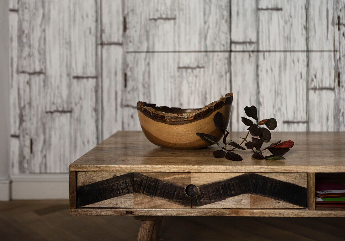 Wooden bowl and leaves on 1960s style table in Somerset home UK