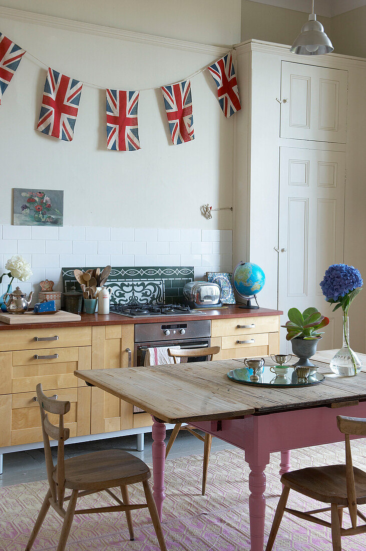 Union Jack Fähnchen in einer Küche in Suffolk mit Holztisch, England, UK