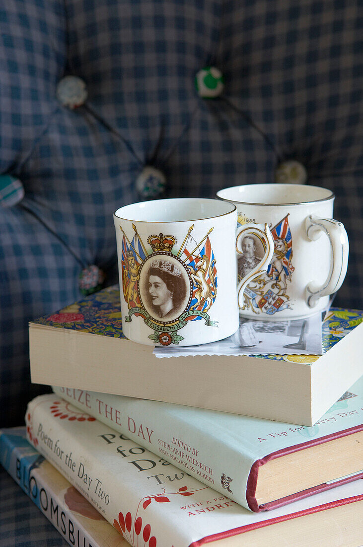 Coronation cups on books in Suffolk home, England, UK
