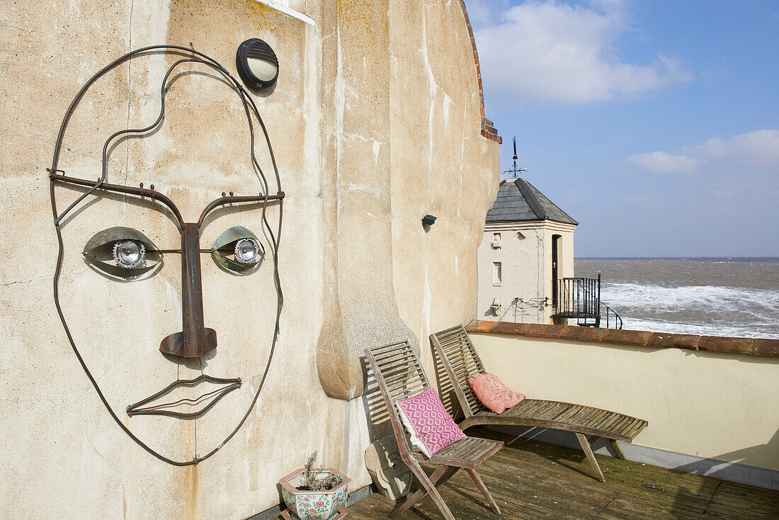 Metal sculpture of human face on exterior of Aldeburgh home Suffolk England UK