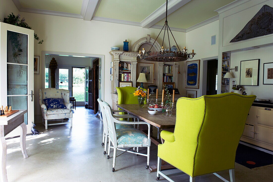 Matching yellow armchairs at wooden dining table in Massachusetts home, New England, USA