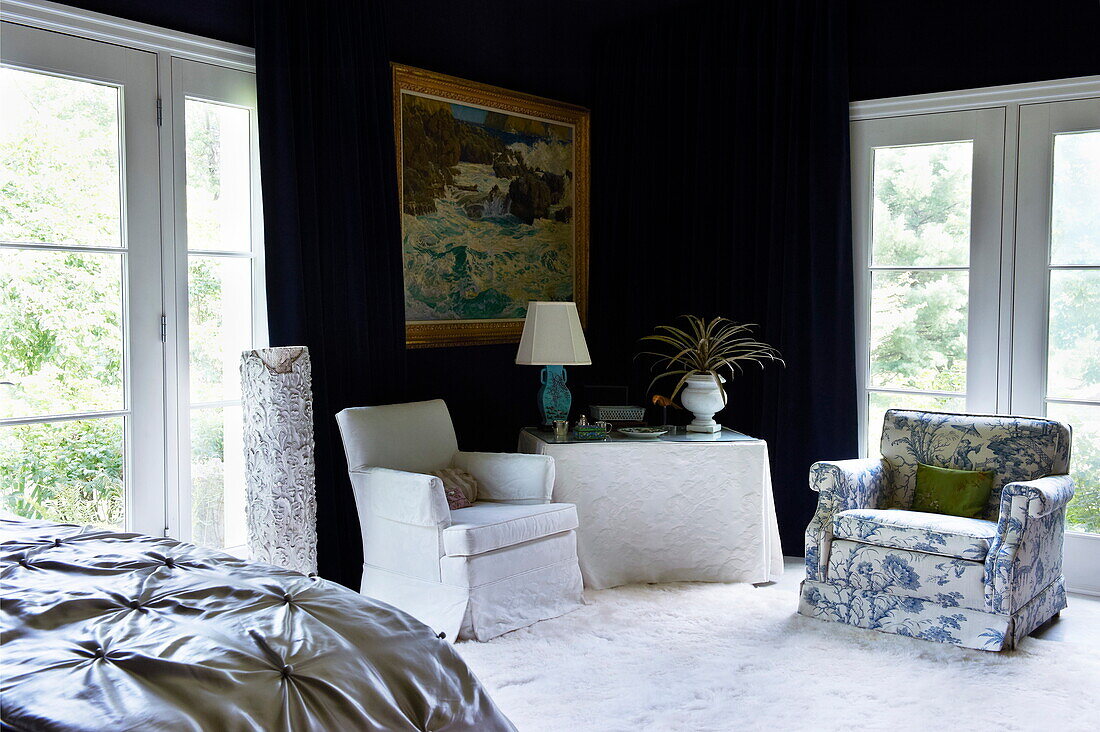 Armchair seating in dark blue bedroom of Massachusetts home, New England, USA