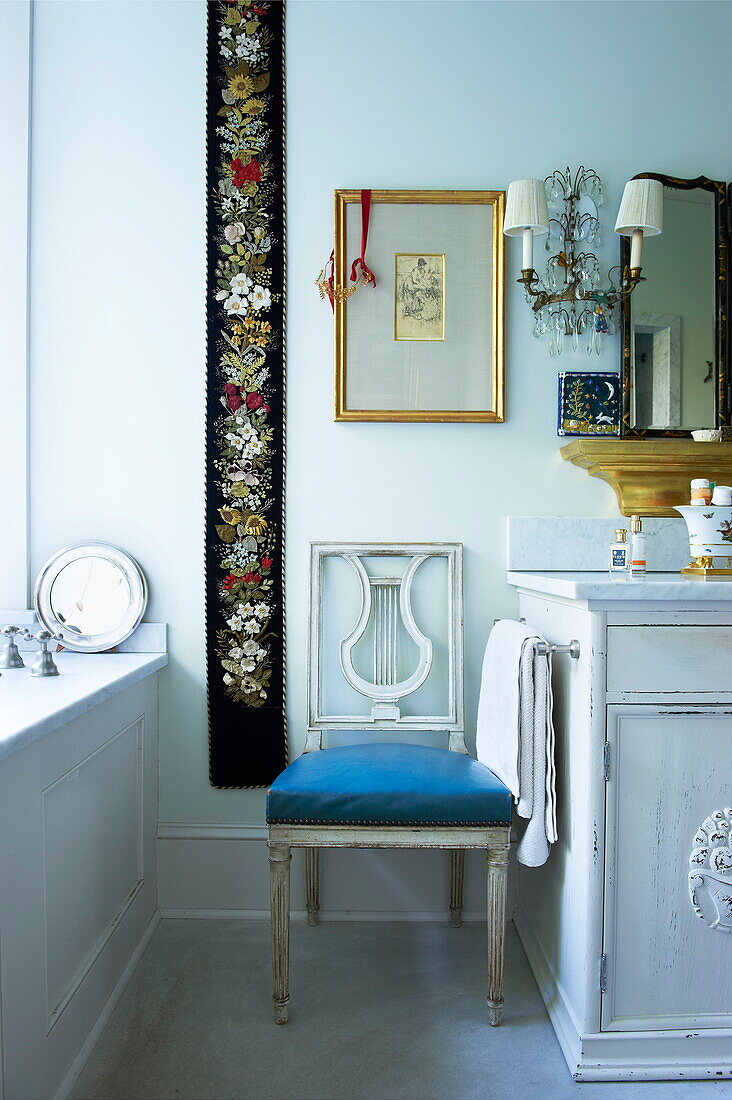 Embroidered wall hanging and chair in bathroom of Massachusetts home, New England, USA