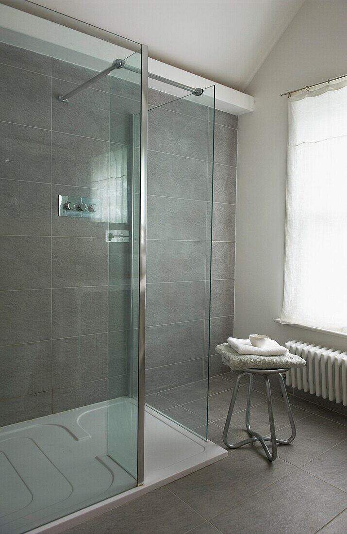 Glass walk-in shower cubicle in tiled wet room of Broadstairs home, Kent, England, UK