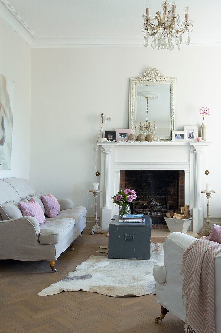 Sofa und Reisetruhe am Kamin im Wohnzimmer eines Hauses in Canterbury, England UK