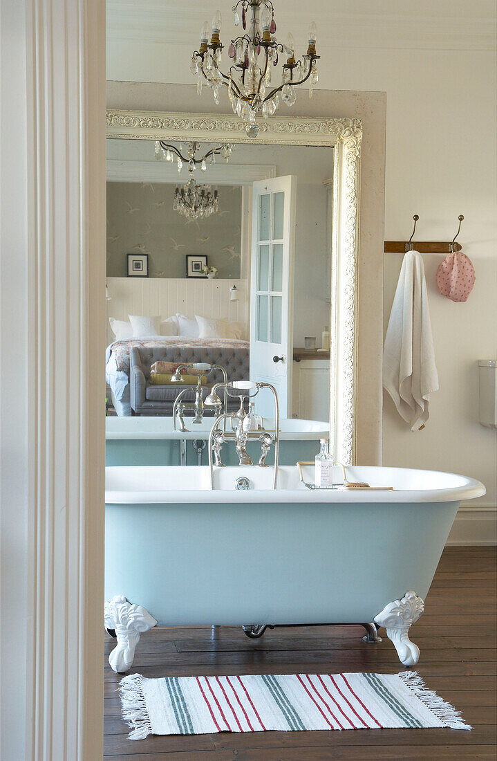 Kronleuchter über einer freistehenden Badewanne, die sich im Spiegel eines Badezimmers in Canterbury, England, spiegelt