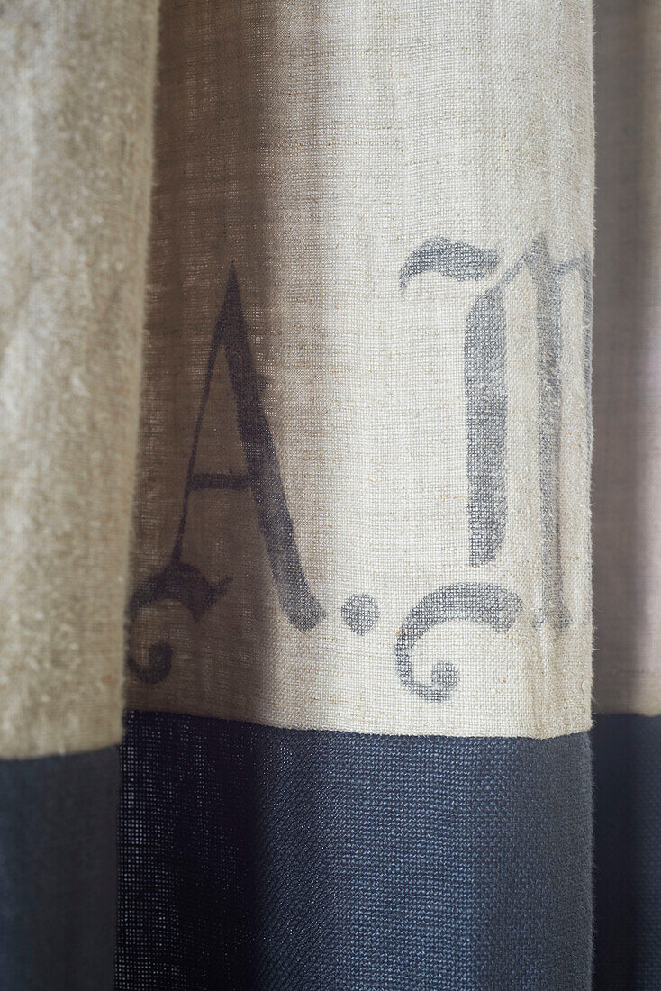 Buchstaben 'A' und 'M' auf hessischem Stoff in einem Haus in Hastings, East Sussex, England, UK