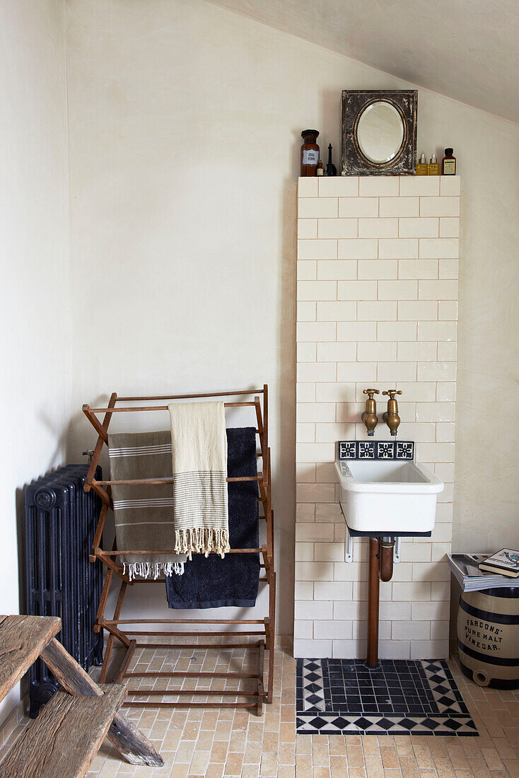 Wäscheständer und kleines Waschbecken im gefliesten Badezimmer eines Cottage in Hastings, East Sussex, England, UK