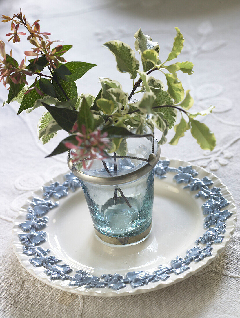 Blumenarrangement und Milchkännchen auf Esstisch in einem Bauernhaus in Gloucestershire, England, UK