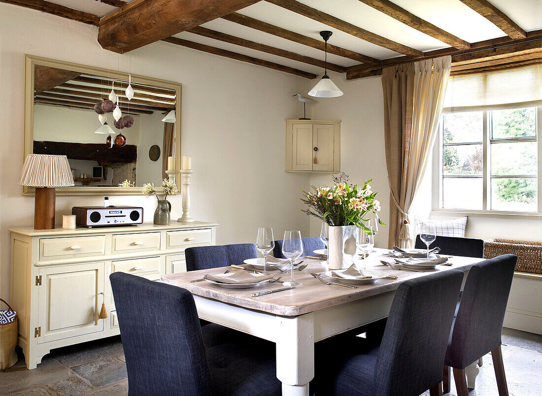 Dining room table and painted sideboard in beamed Gloucestershire farmhouse England UK