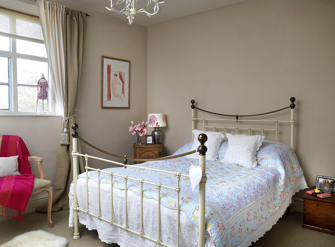 Wrought iron bed in room of Gloucestershire farmhouse England UK