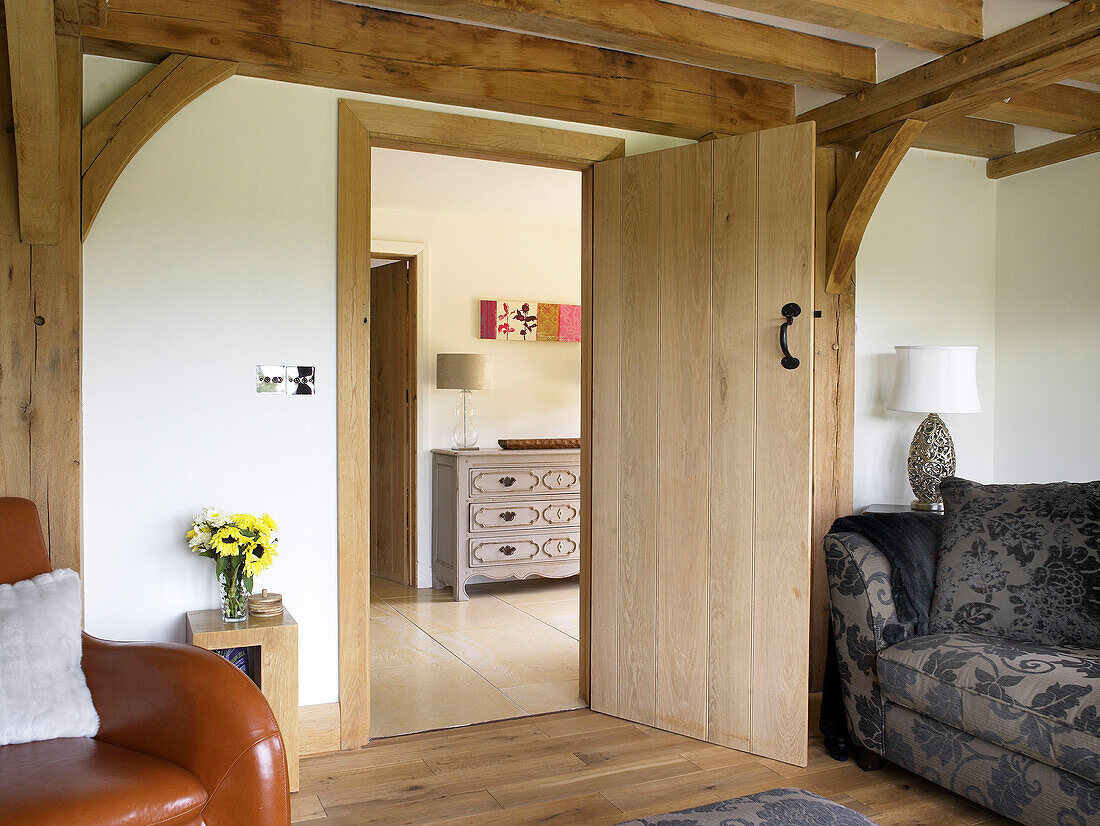 View through timber doorway to hallway of Gloucestershire cottage England UK