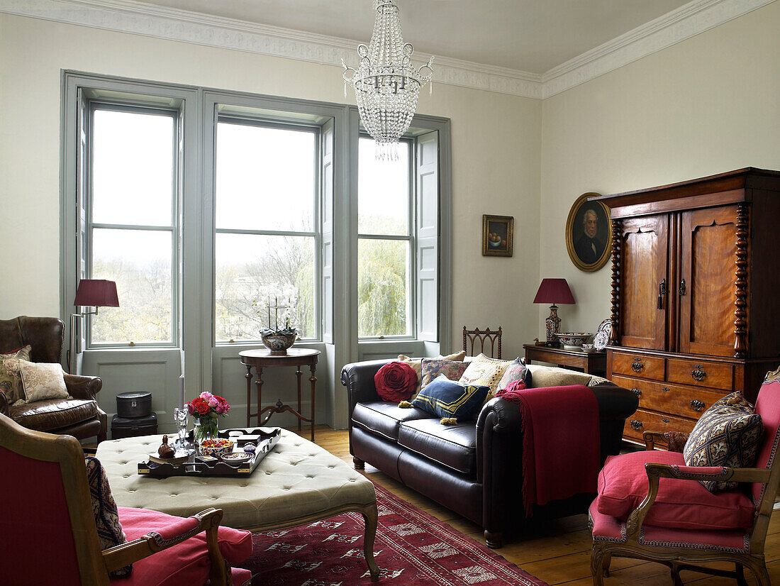 Leather sofa and antique cabinet in living room of city of Bath home Somerset, UK