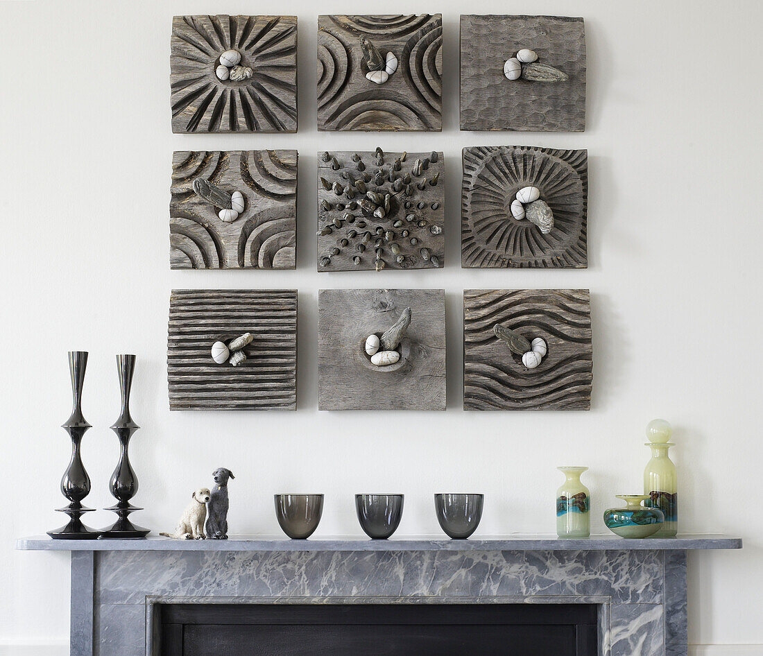 Modern art installation and homeware above marble fireplace in contemporary Bath home, Somerset England, UK