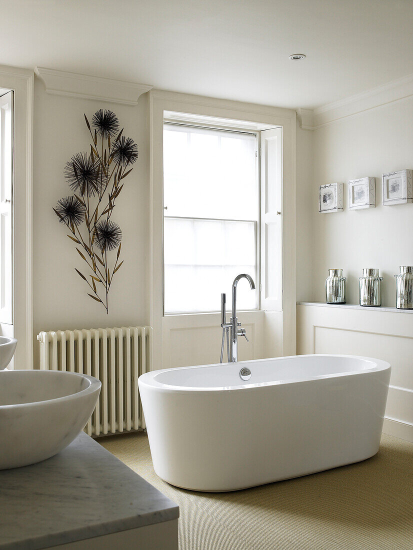 Freistehende Badewanne mit geblümten Wänden im Badezimmer eines modernen Hauses in Bath, Somerset, England, UK