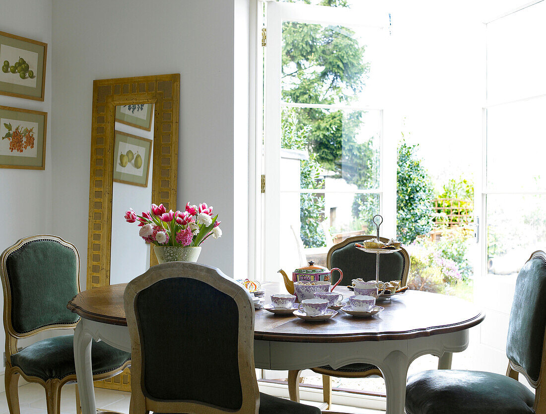 Teeservice auf einem Esstisch mit Stühlen in der Küche eines Hauses in der Stadt Bath, Somerset, England, UK