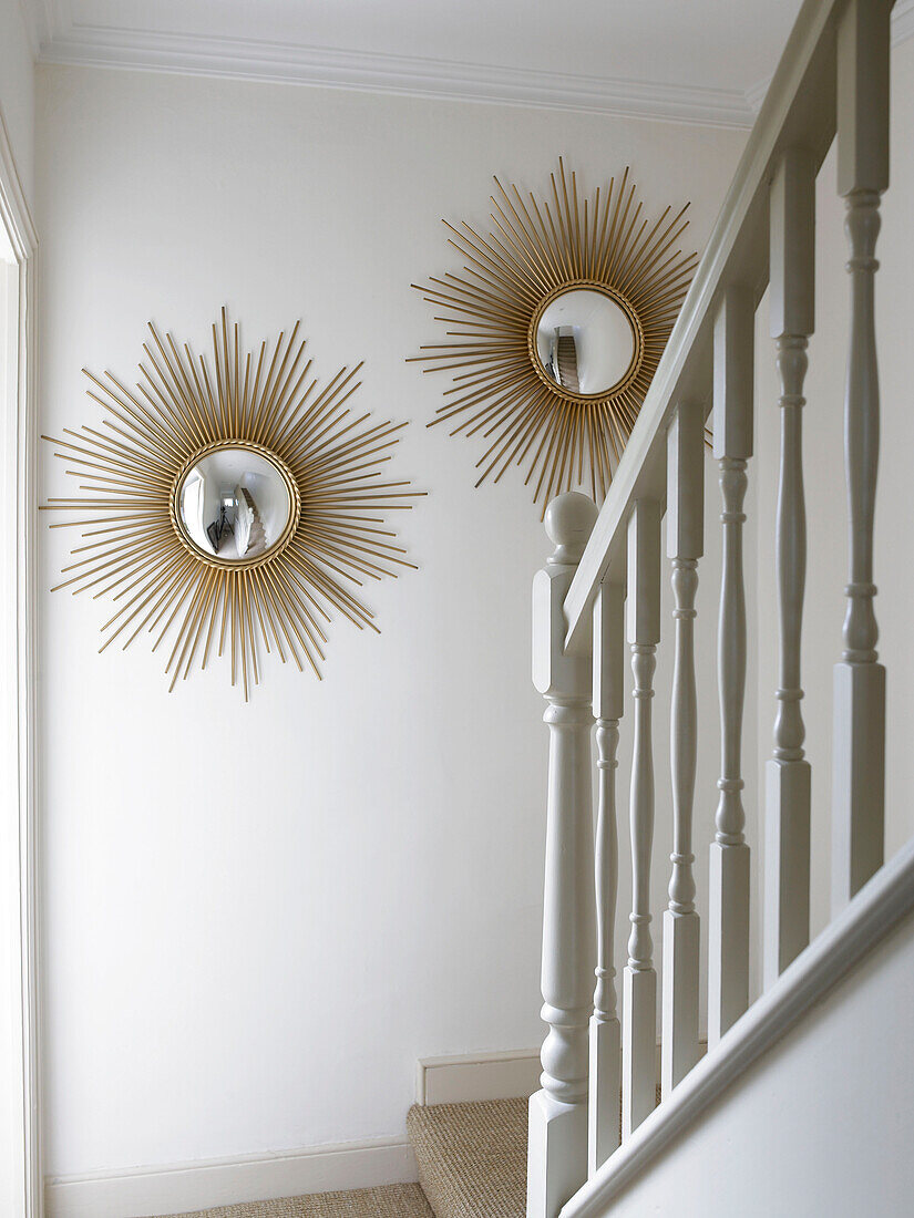 Sunburst convex mirrors in staircase of city of Bath home Somerset, England, UK