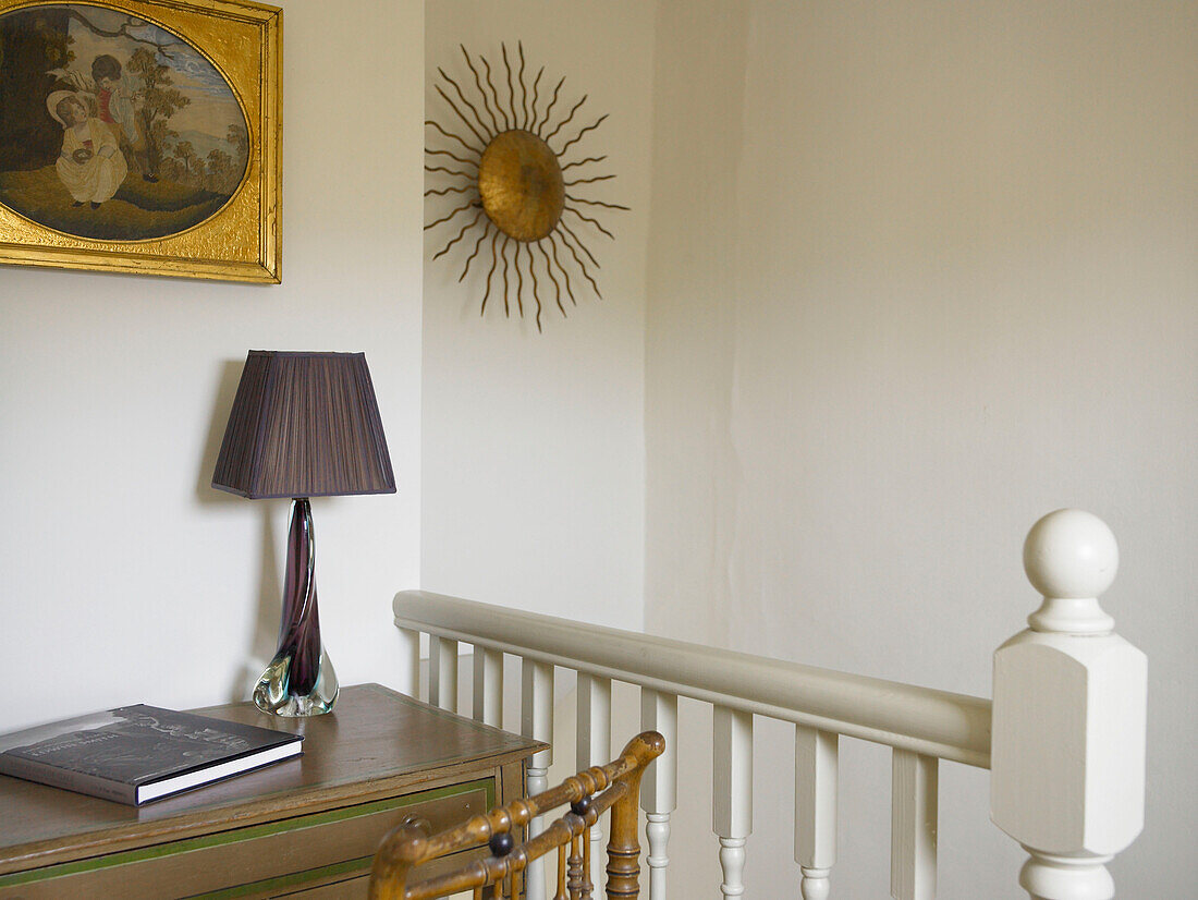 Lampe auf Schreibtisch, darüber Kunstwerk mit Blattgold und Skulptur auf Treppenabsatz in der Stadt Bath, Somerset, England, UK