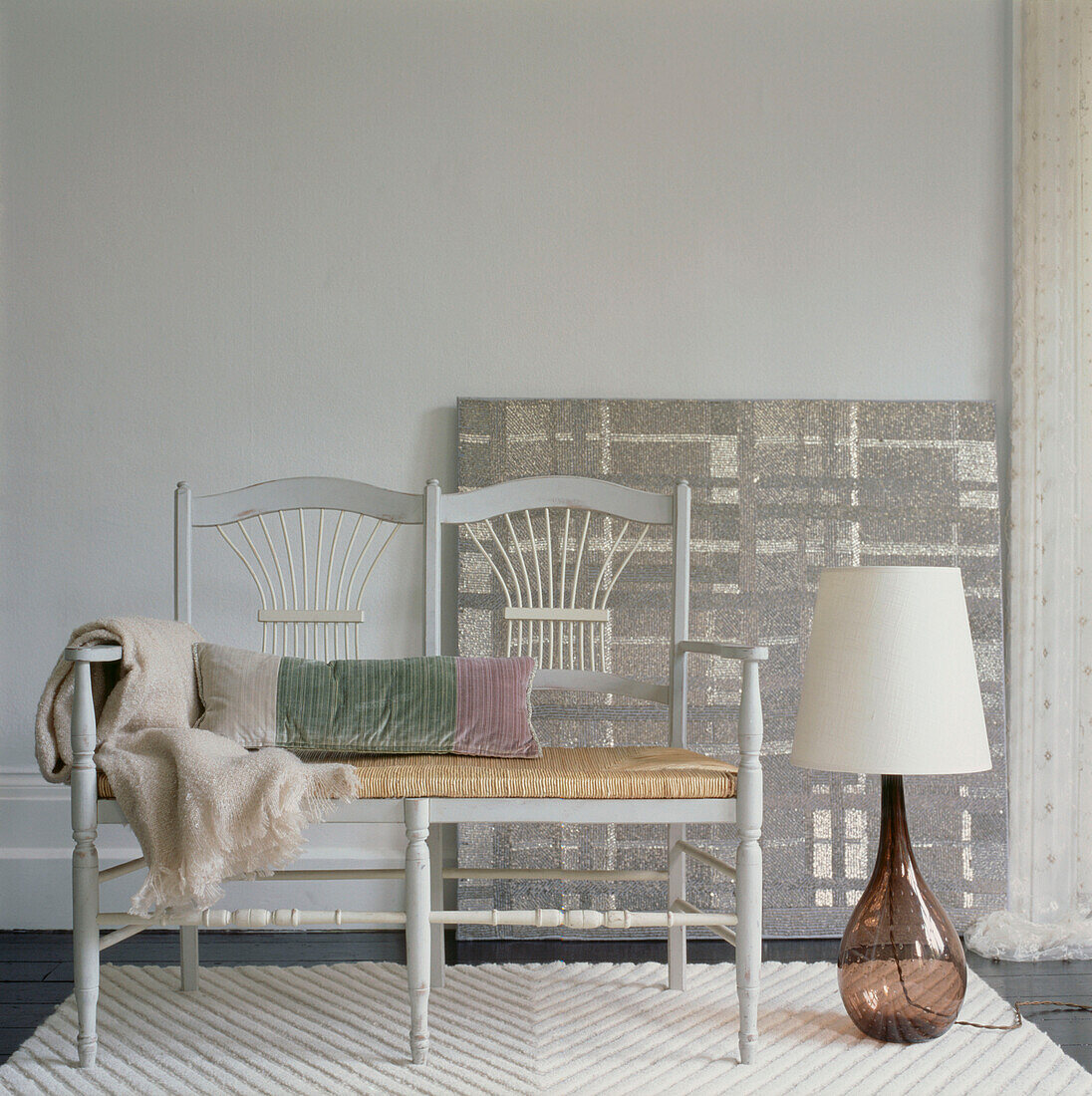 Minimalistisches Wohnzimmer mit Sessel, Teppich und Stehlampe