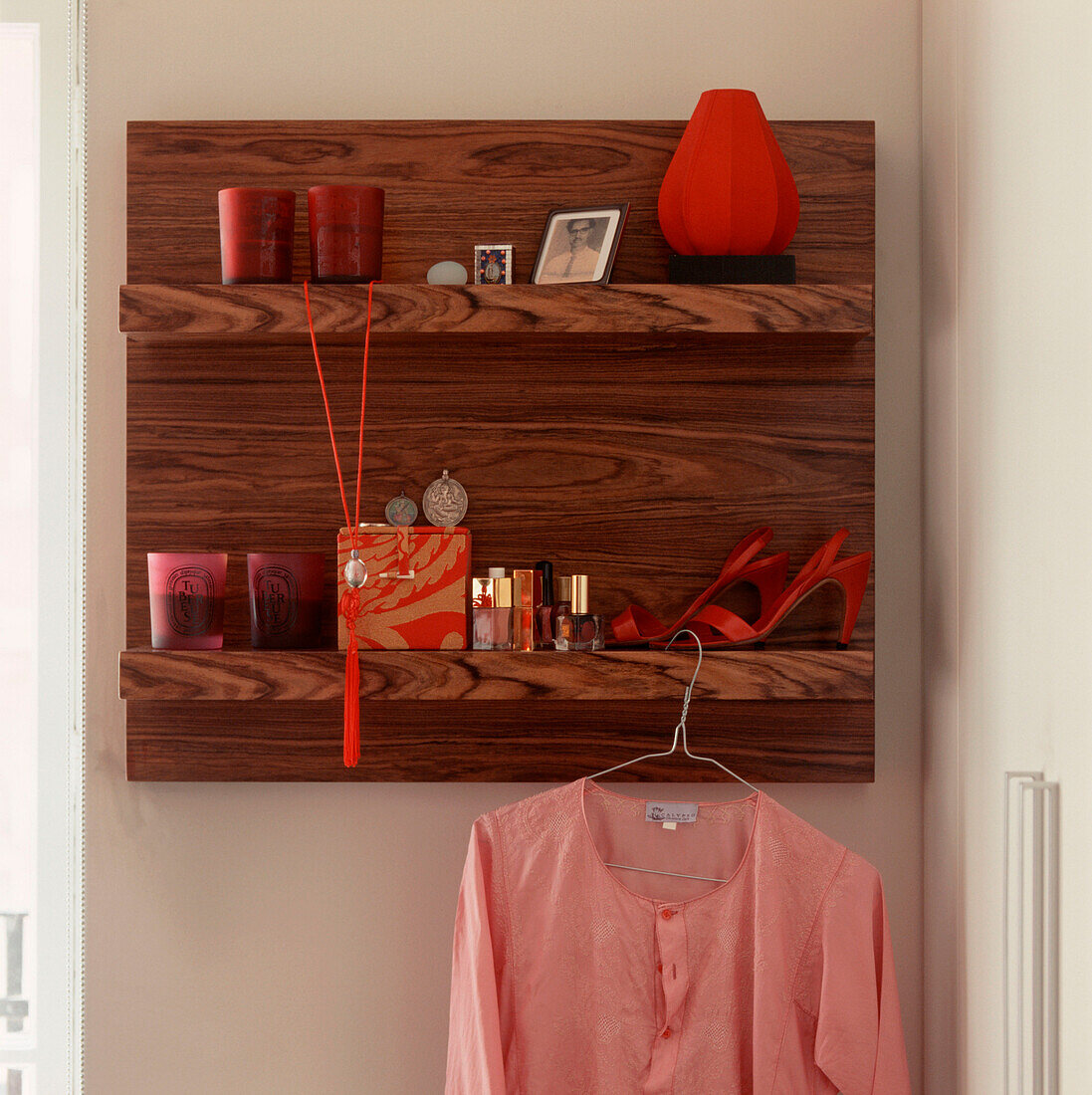 Wooden wall hung shelving unit with personal belongings